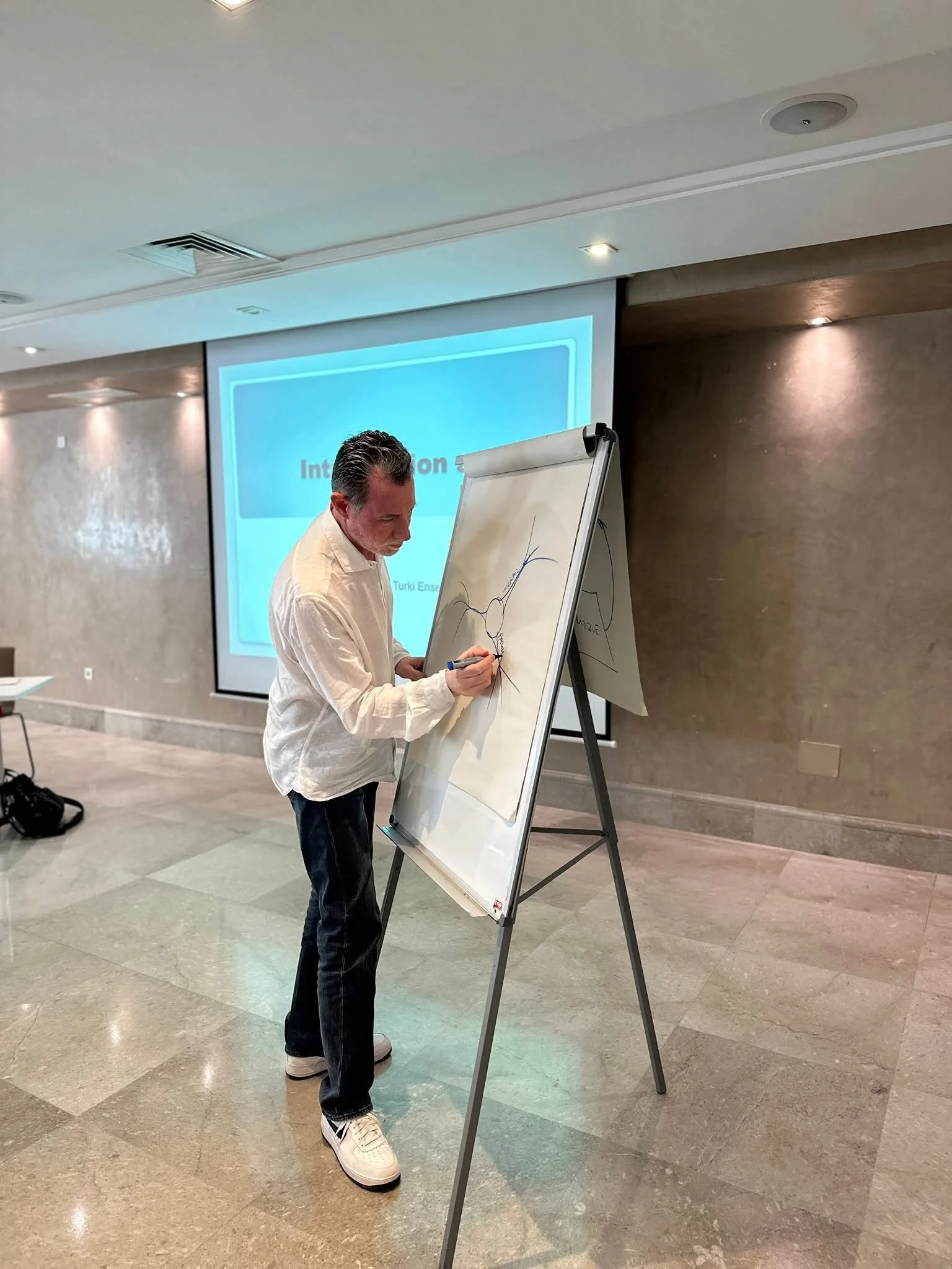 Karim Turki en formation PNL, animation devant un flip chart